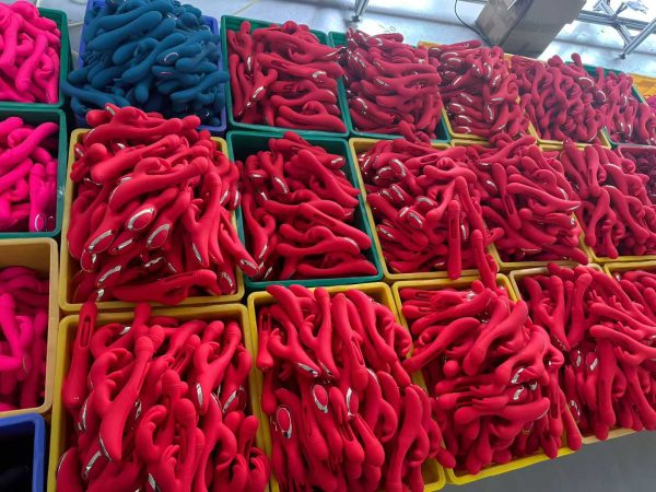 Diverse collection of Dongguan Xishang vibrators in various shapes (cactus, rabbit, classic) and colors (purple, teal, red) laid out on a table, demonstrating product innovation and customization options.