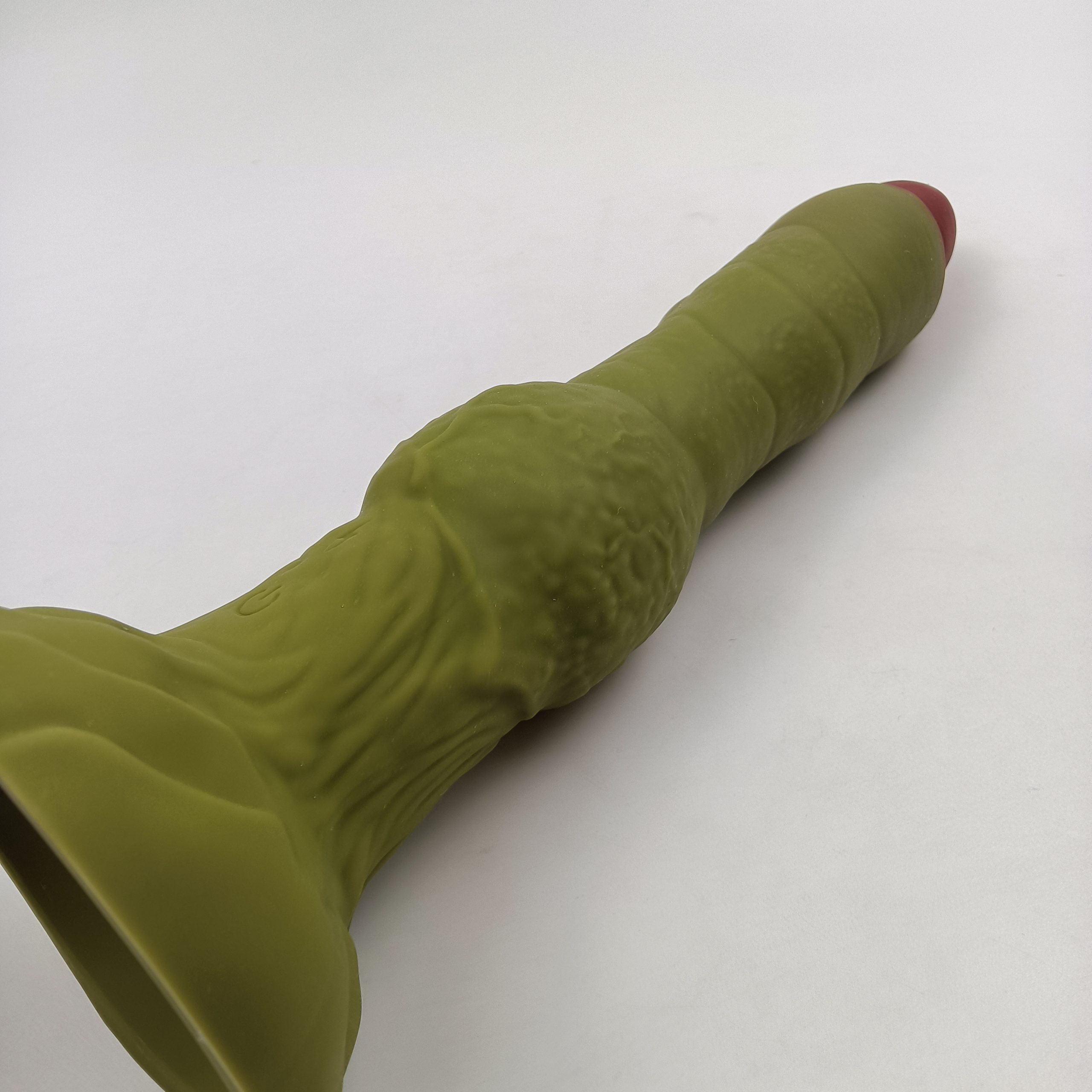 Green alien thrusting vibrator with remote control side profile view