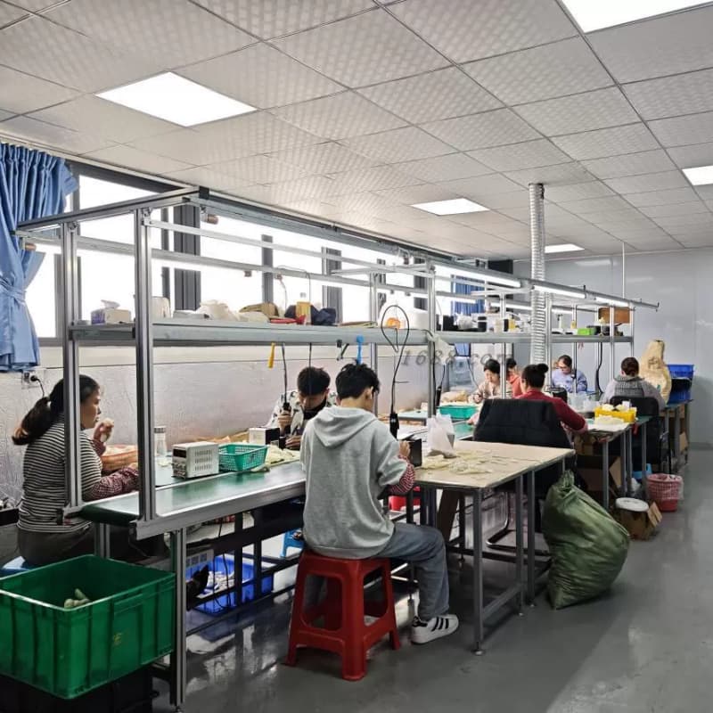 Busy assembly line with workers manually assembling products to ensure quality control.