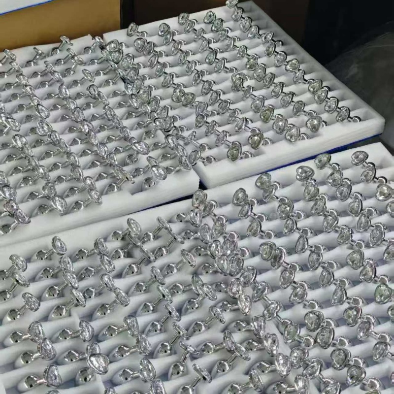 PleasureMo jeweled glass butt plug wholesale with clear crystal heart and shiny metal base in foam tray