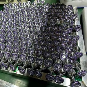 Bulk purple amethyst heart shaped jeweled glass anal plugs with shiny metal bases at PleasureMo factory