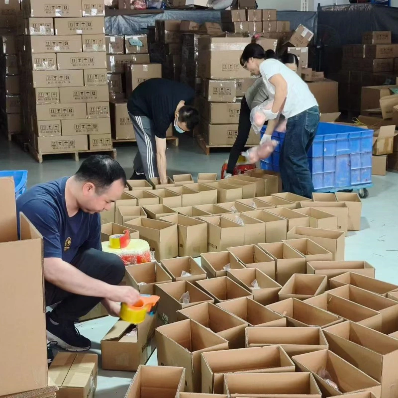 Workers packing wholesale adult toys into cartons for bulk order shipment